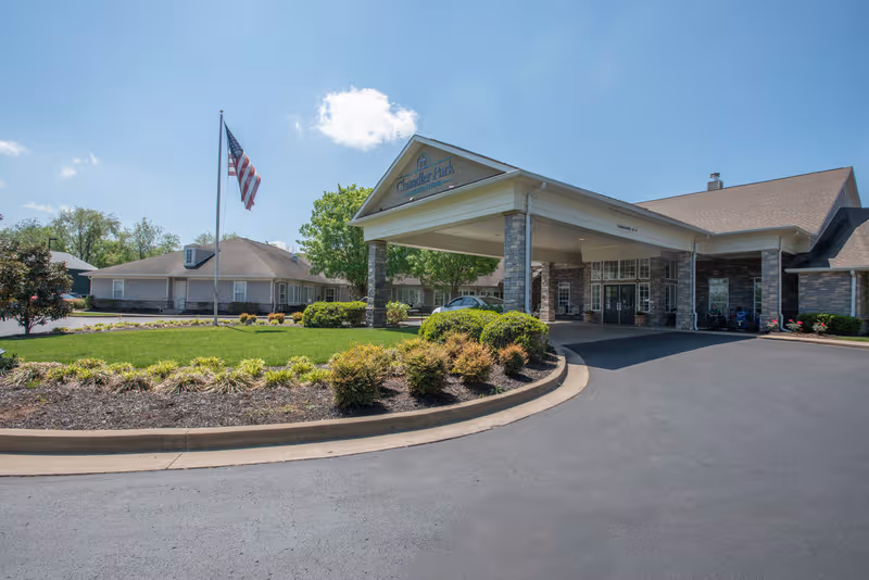 Exterior view of Chandler Park Assisted Living entrance with driveway and landscaping.