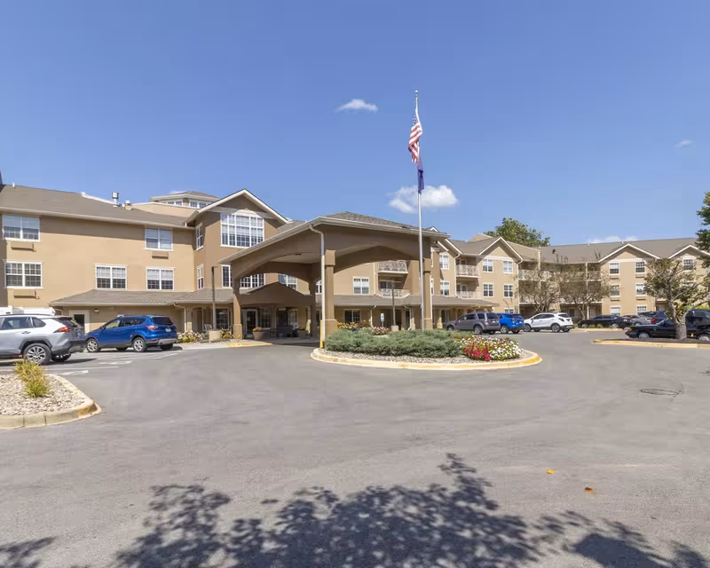 Beige StoryPoint Louisville East senior living building with covered entrance and parking.