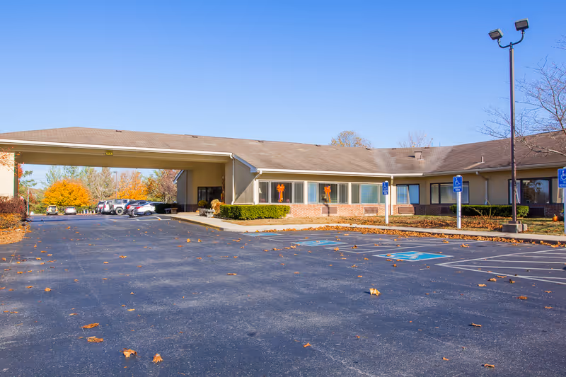Single-story senior living facility with covered entrance and parking lot.