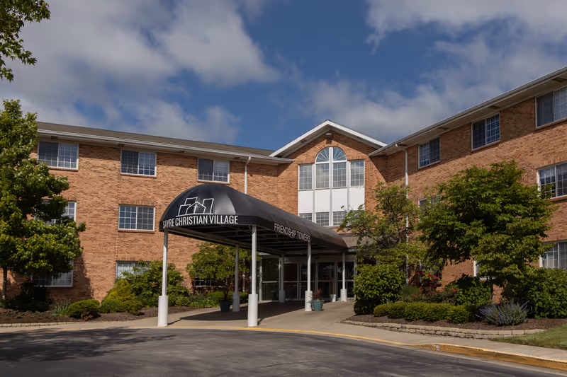 Brick senior living building with a covered entrance and Friendship Towers sign.