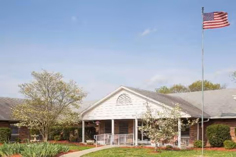 Front view of Colonial Center senior living facility with flagpole and landscaped entrance.
