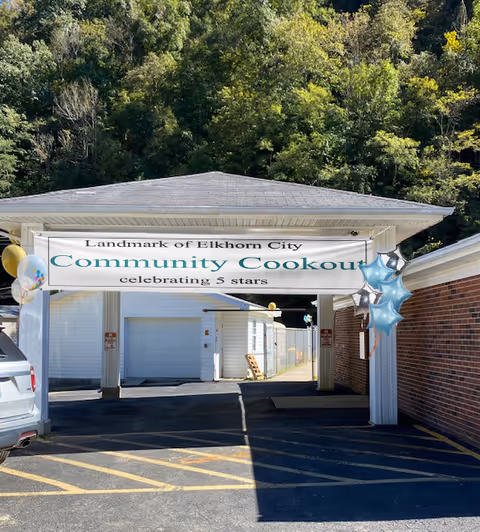 Front entrance of Landmark of Elkhorn City with a banner for a community cookout and balloons.