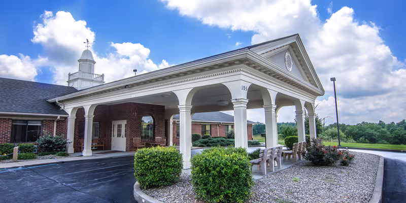 Exterior view of Edgewood Estates front entrance with arches and chairs.