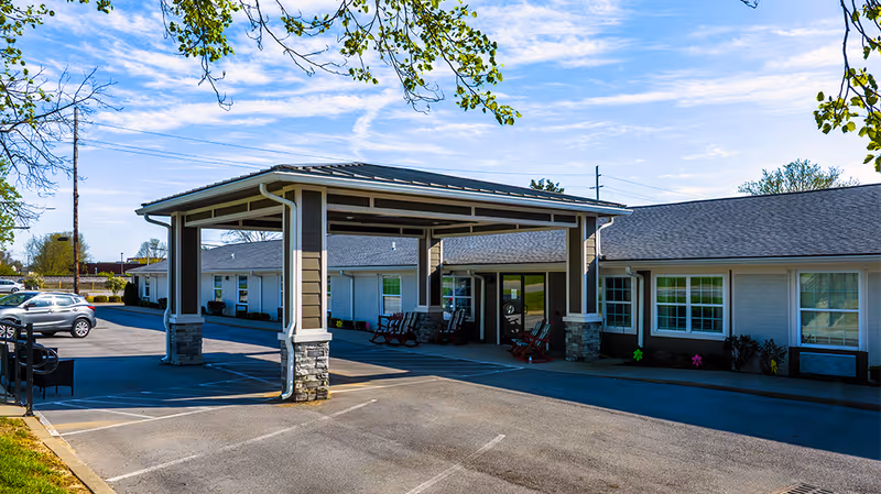 Exterior view of Creekside on Whipps Mill with a covered entrance and rocking chairs.