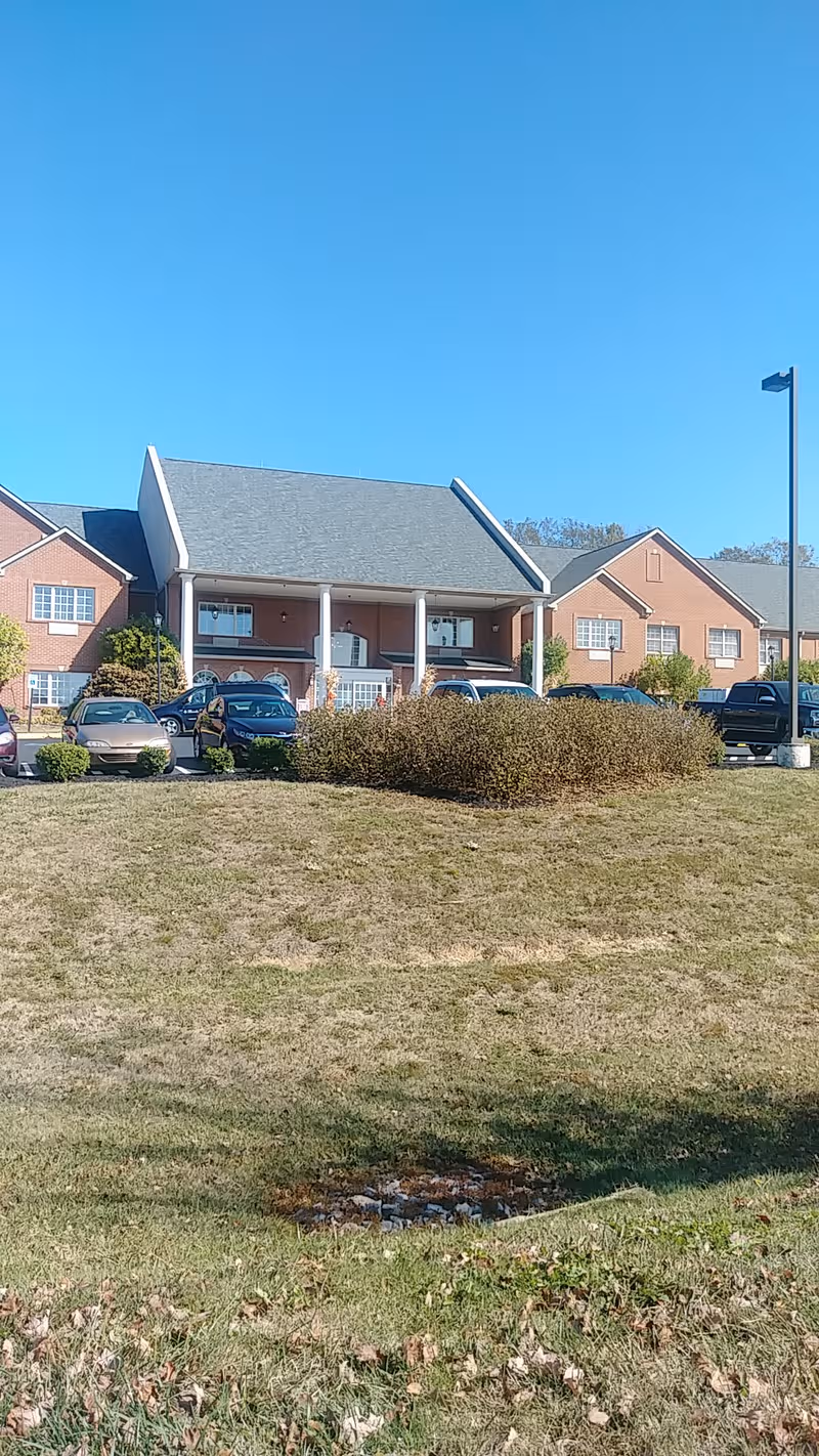 Exterior view of Rose Mary C. Brooks Place, brick building with parked cars.