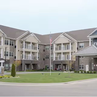 Front view of Calumet Trace senior living building with balconies and manicured lawn.