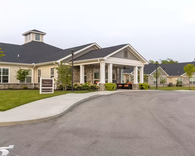 StoryPoint Middletown senior living entrance with columns, sign, and landscaped curbside area.