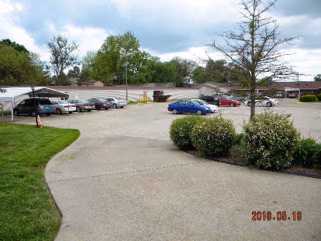 Front exterior view of Twin Oaks Assisted Living, showing a parking lot and landscaping.