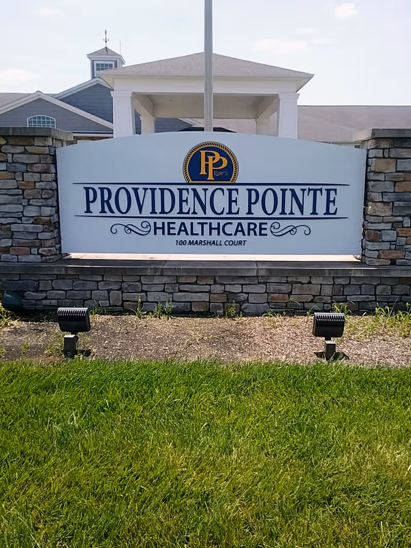 Providence Pointe Healthcare sign mounted on a stone wall at the facility entrance.