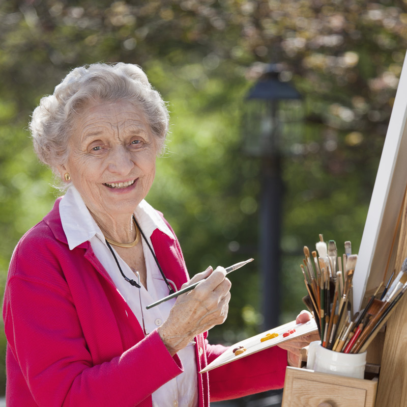 Senior woman painting outdoors